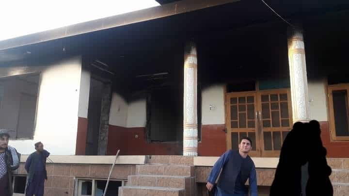 A man poses in front of a house