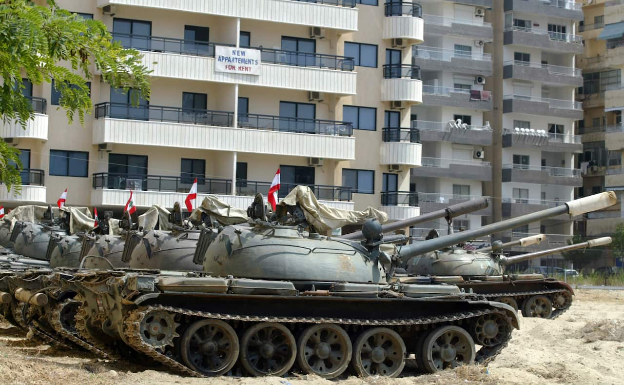 A row of tanks parked in front of apartment blocks