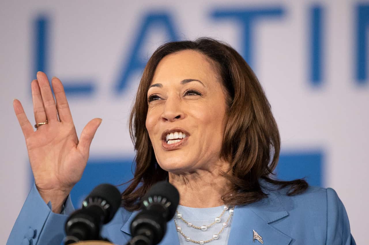 US Vice President Kamala Harris wearing a blue blazer and blue top while speaking at a campaign rally 