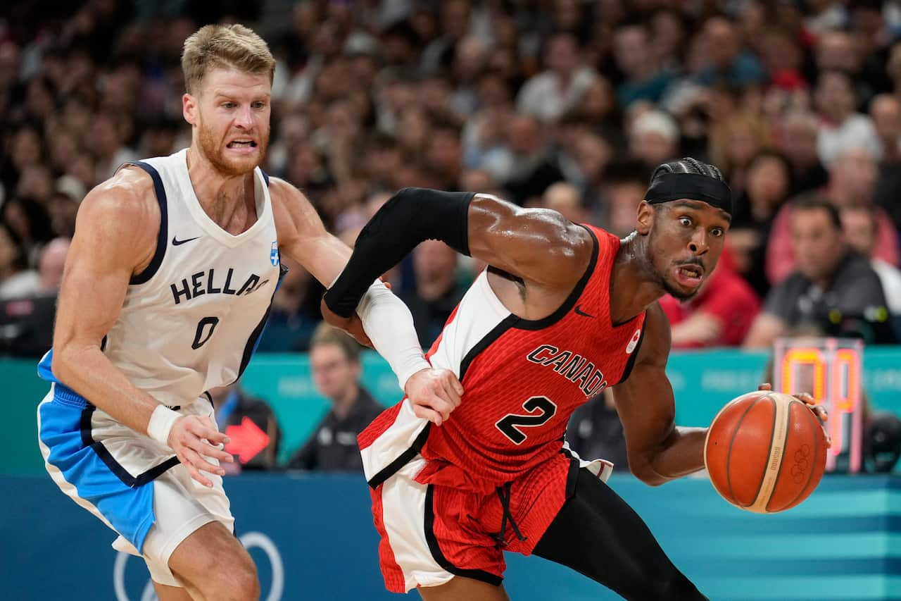 Shai Gilgeous-Alexander, of Canada, drives past Thomas Walkup, of Greece, during a men's basketball game at the Paris Olympics.