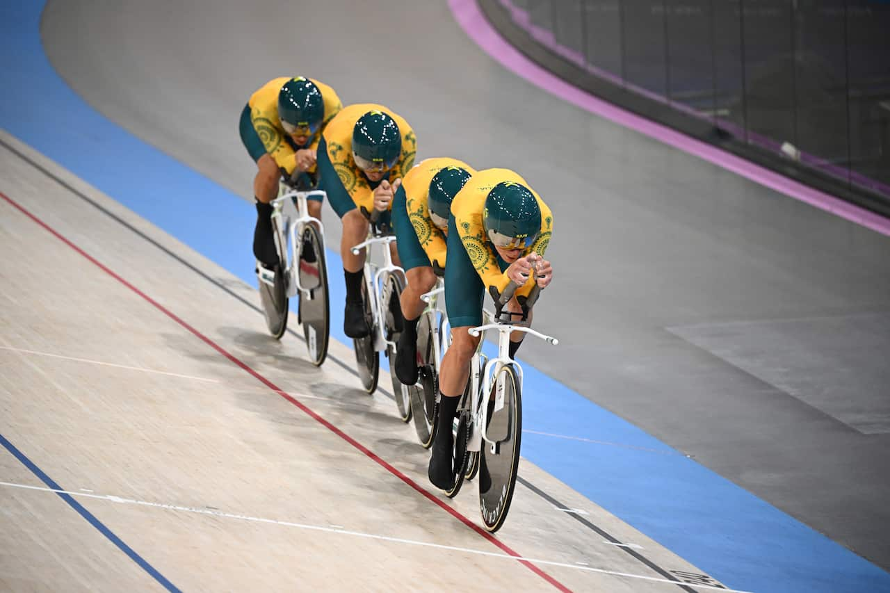 Four men in a line on bicycles