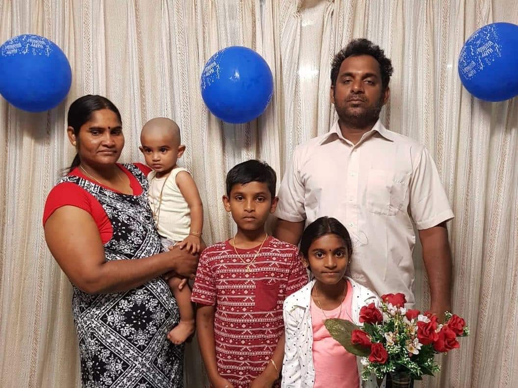 A family picture of a man and a woman and three children