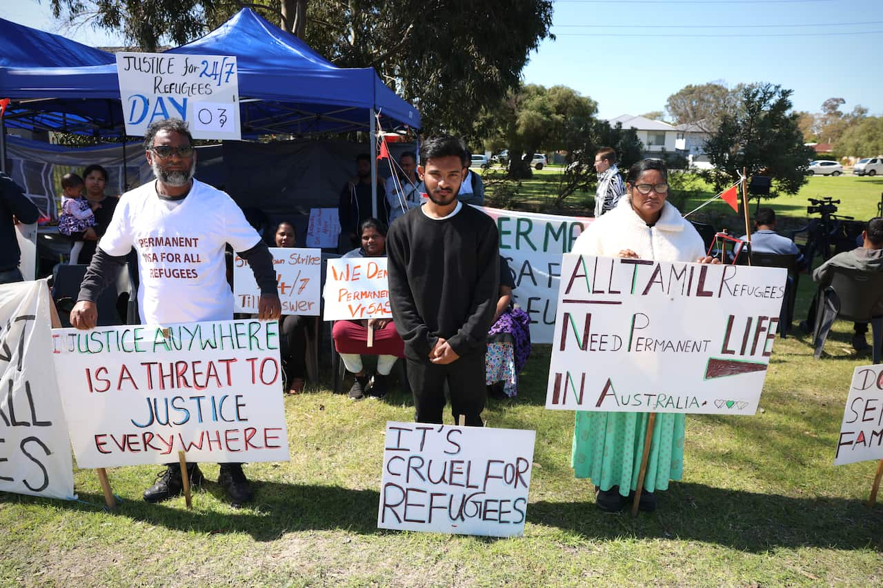 A high school student seeking asylum stands alongside his parents at a Perth protest event calling for refugee permanency in Australia.