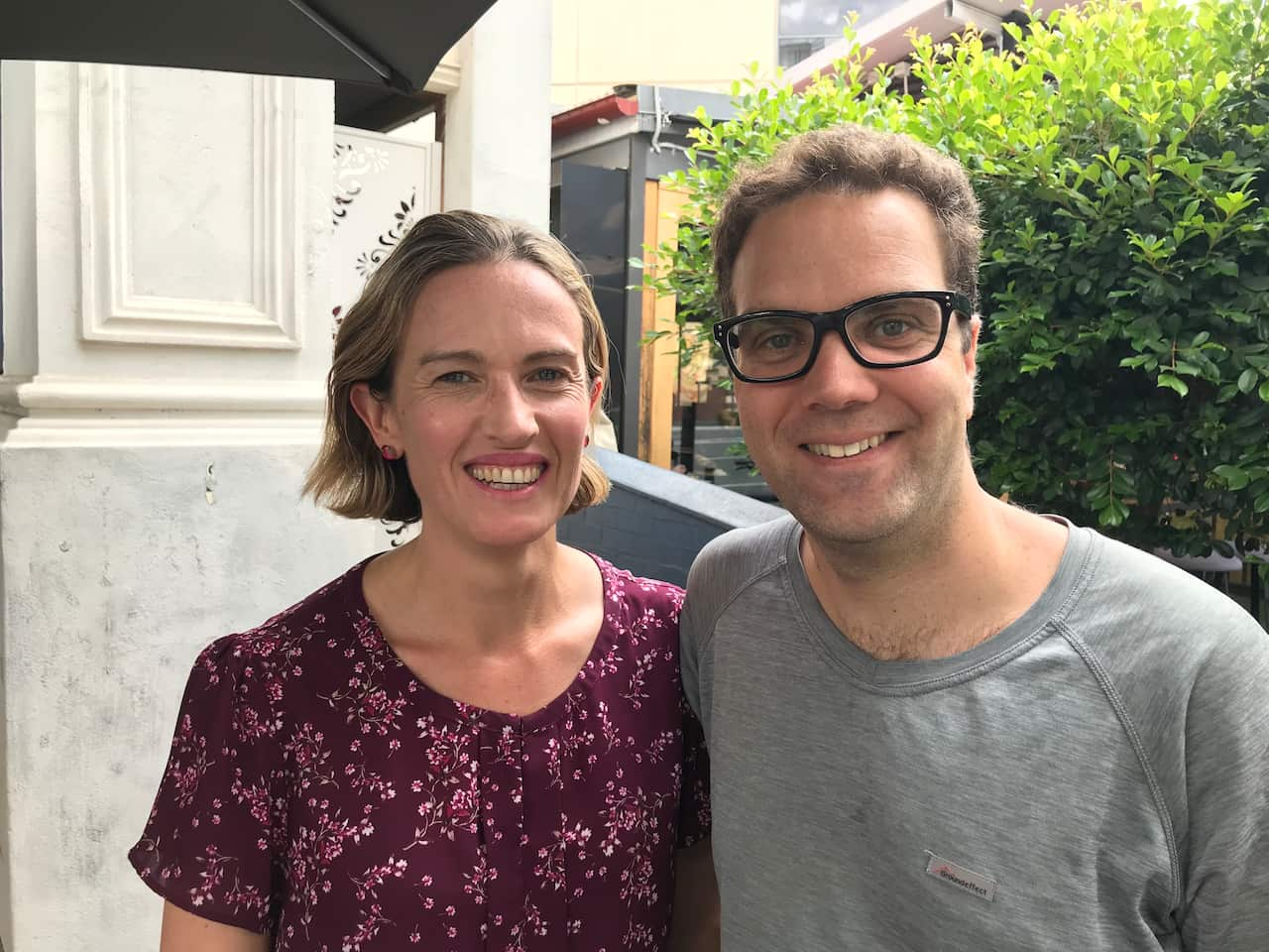 a woman and a man standing next to each other outside