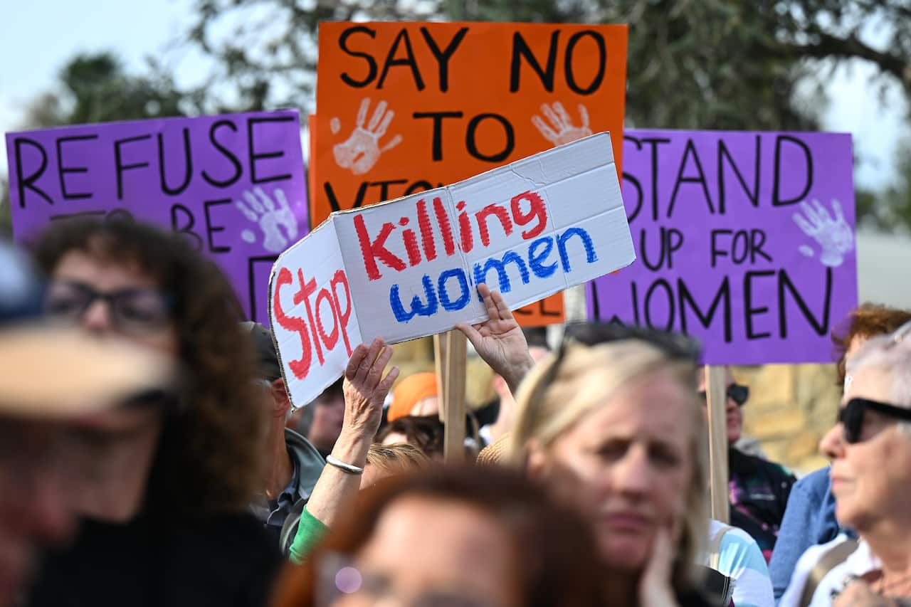 A woman's hands hold up a sign saying 