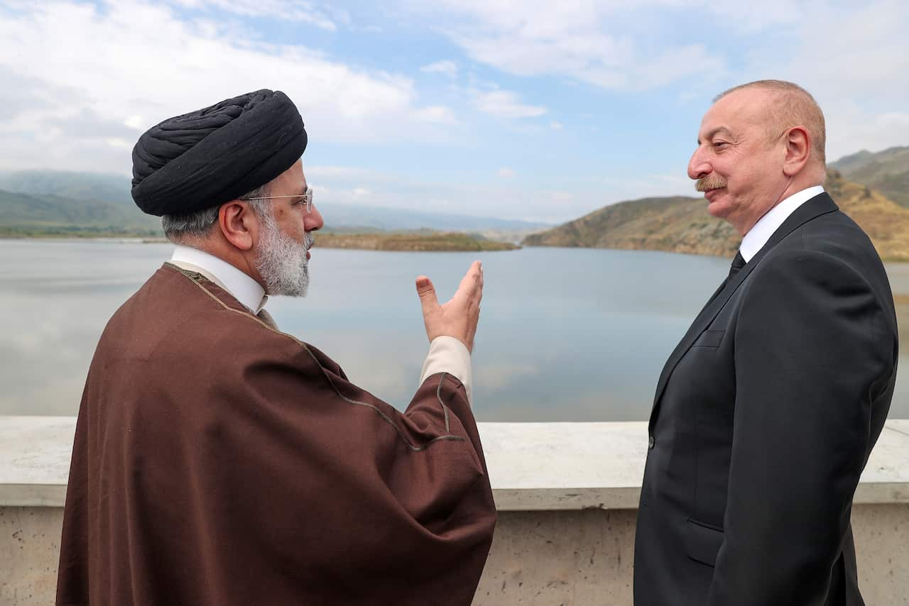 Two men speaking near a dam