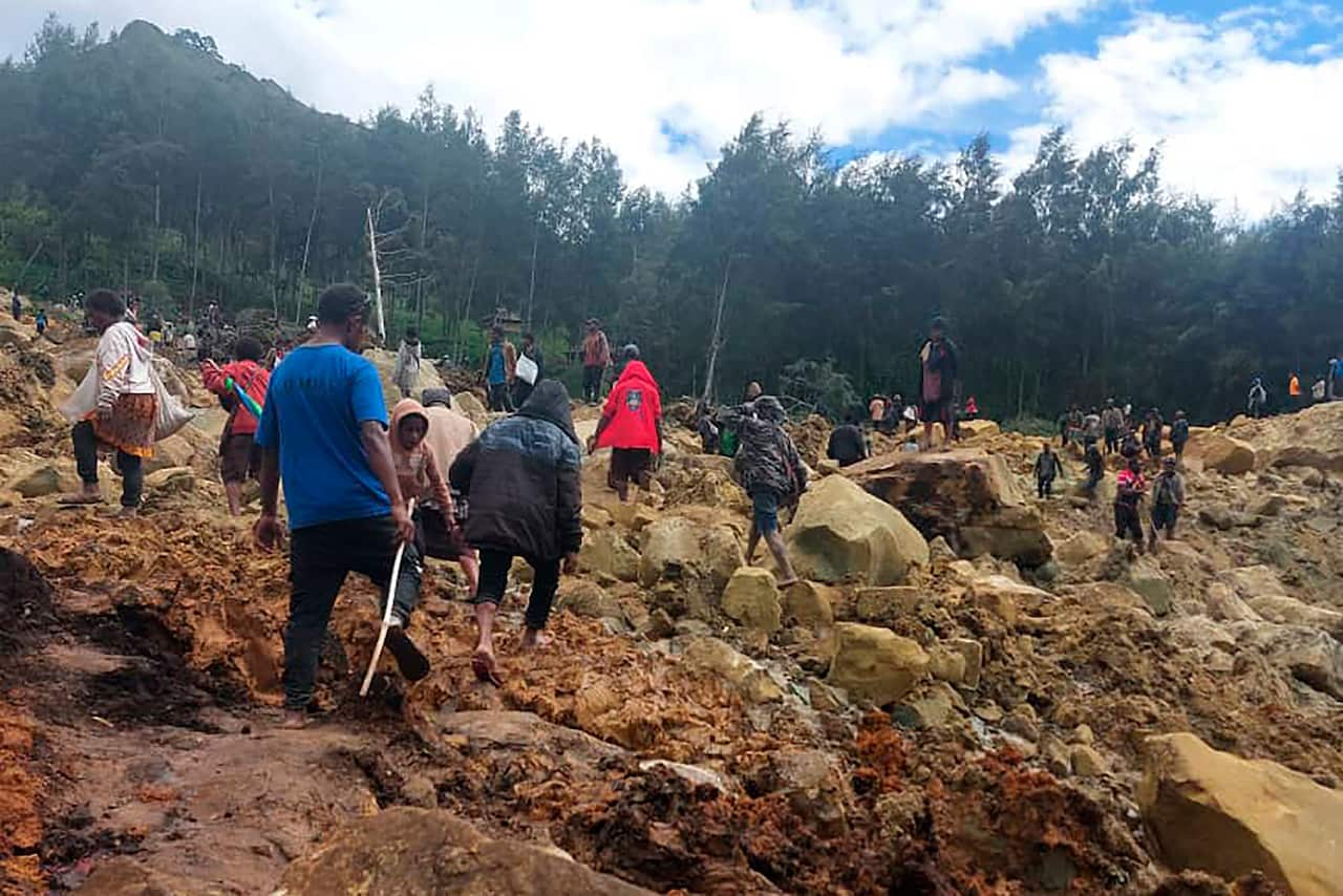 People seen in an area of a massive landslide