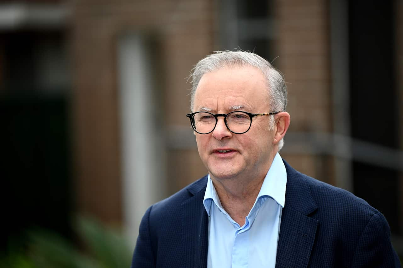 Anthony Albanese wearing a dark blue jacket and blue shirt speaking outside.