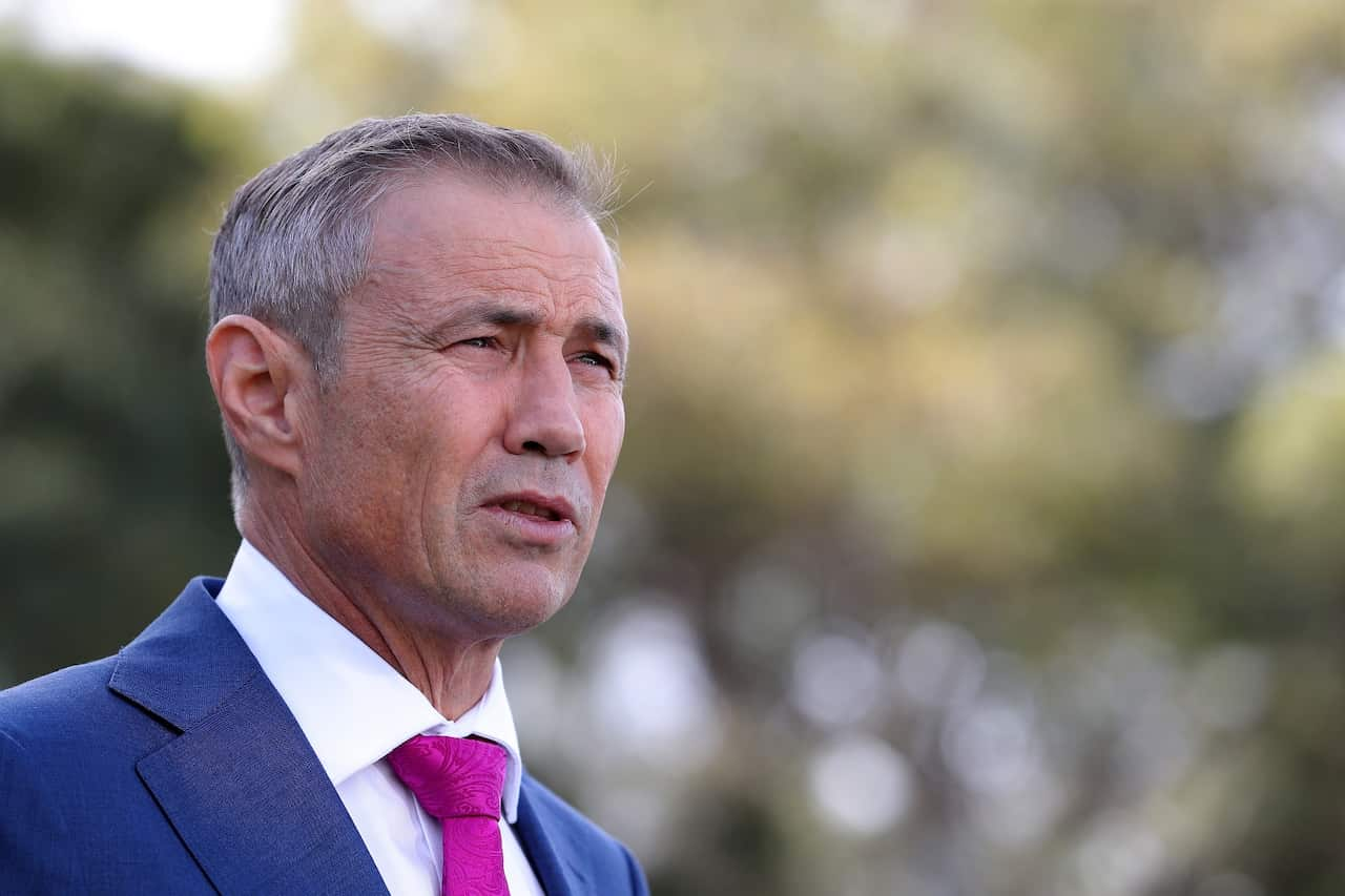 A man in a blue suit and purple tie.