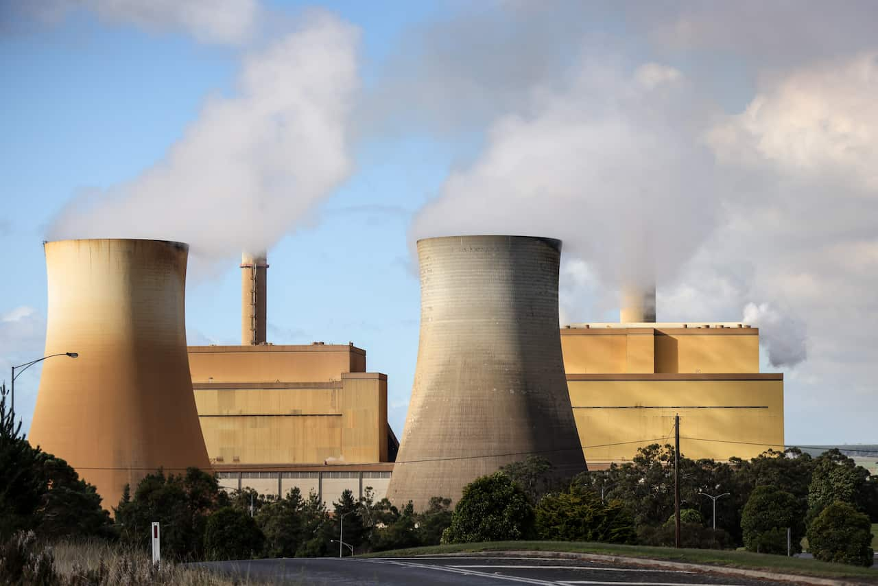 A power station with clouds billowing from the buildings.