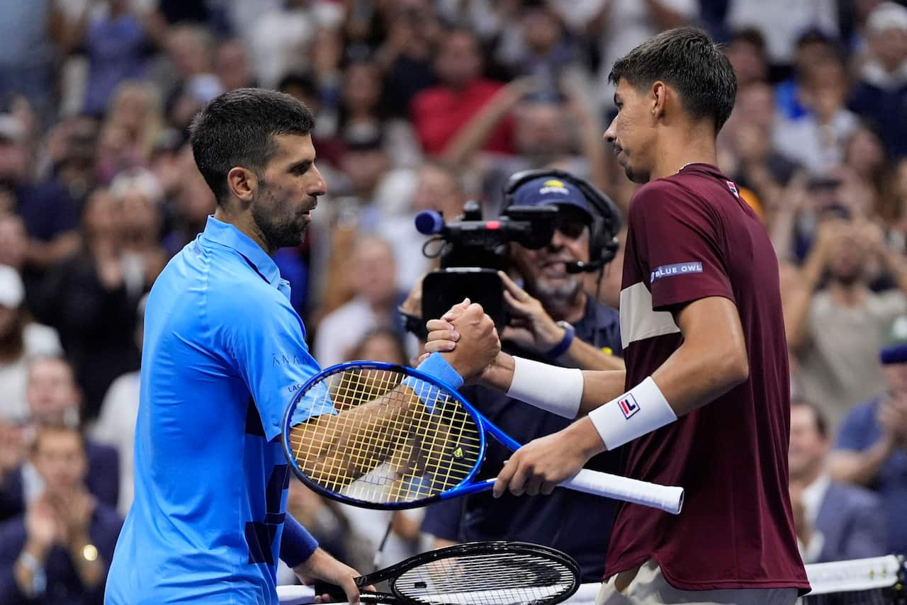 Two male tennis players shake hands. 