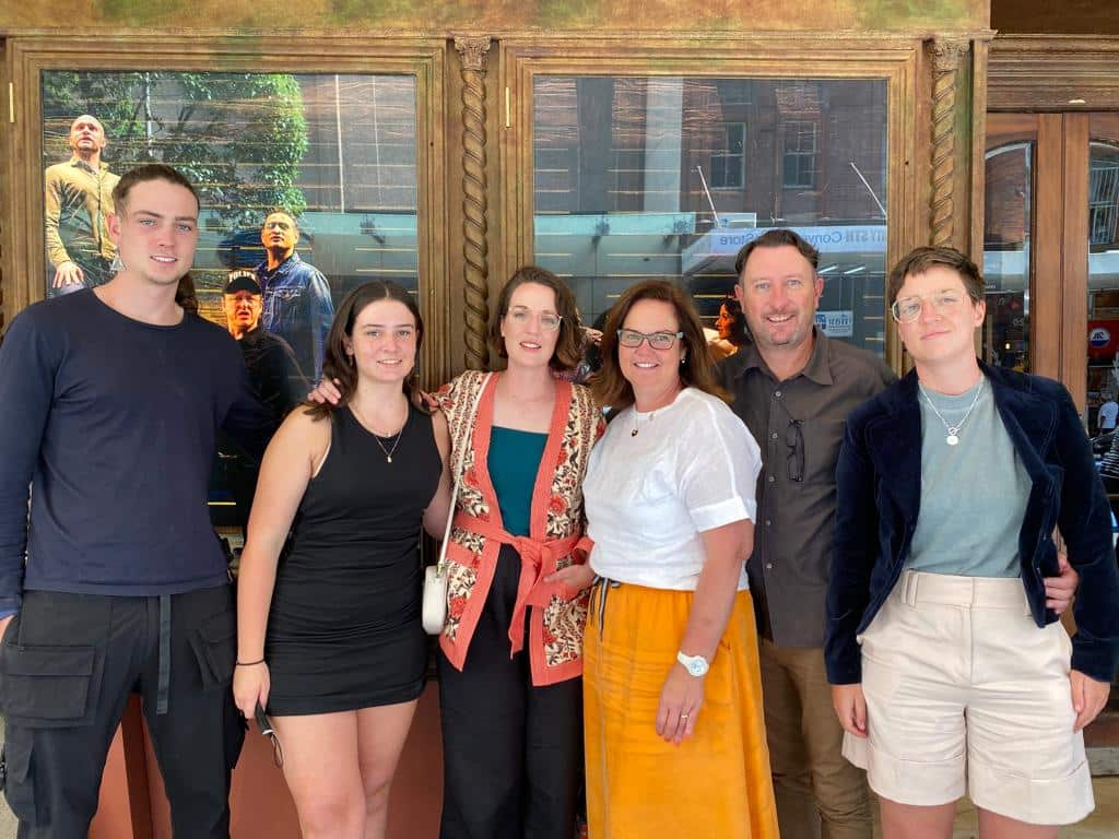 Six people standing in front of a theatre