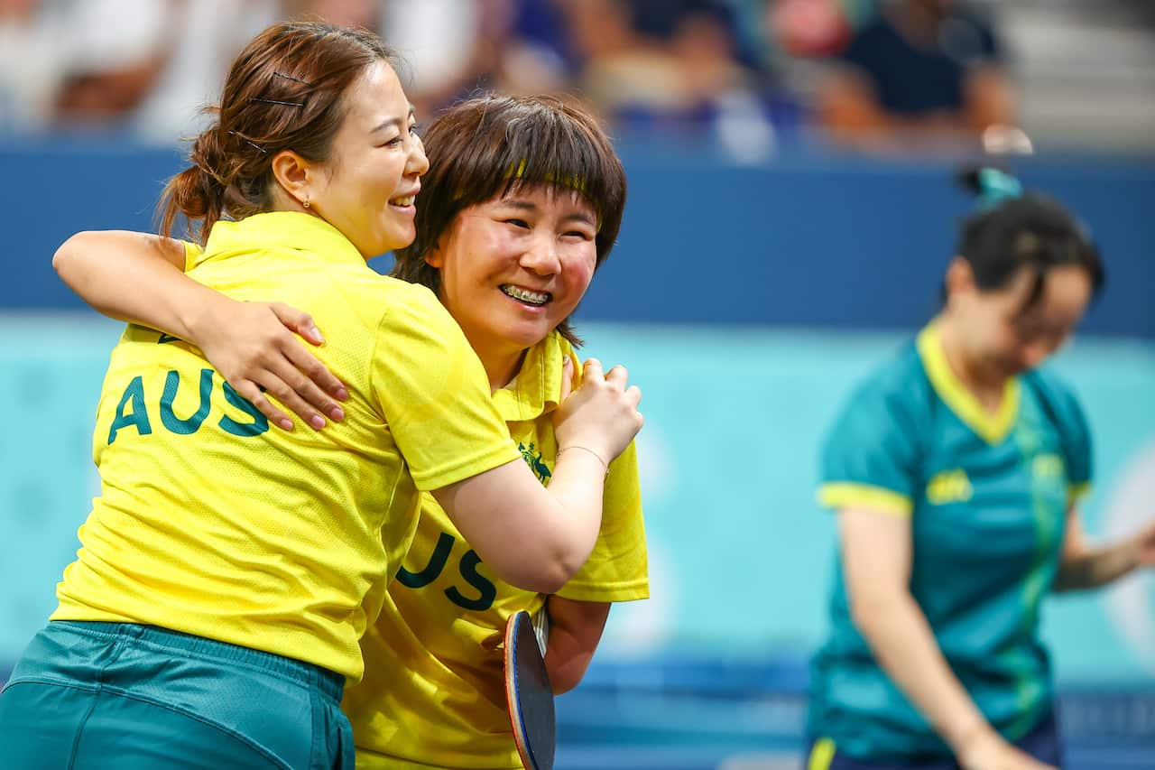 Two women celebrate after winning a gold medal. 