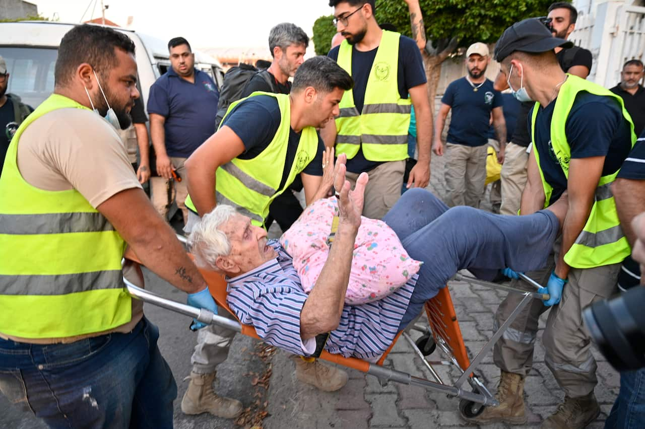 An old man carried on a stretcher