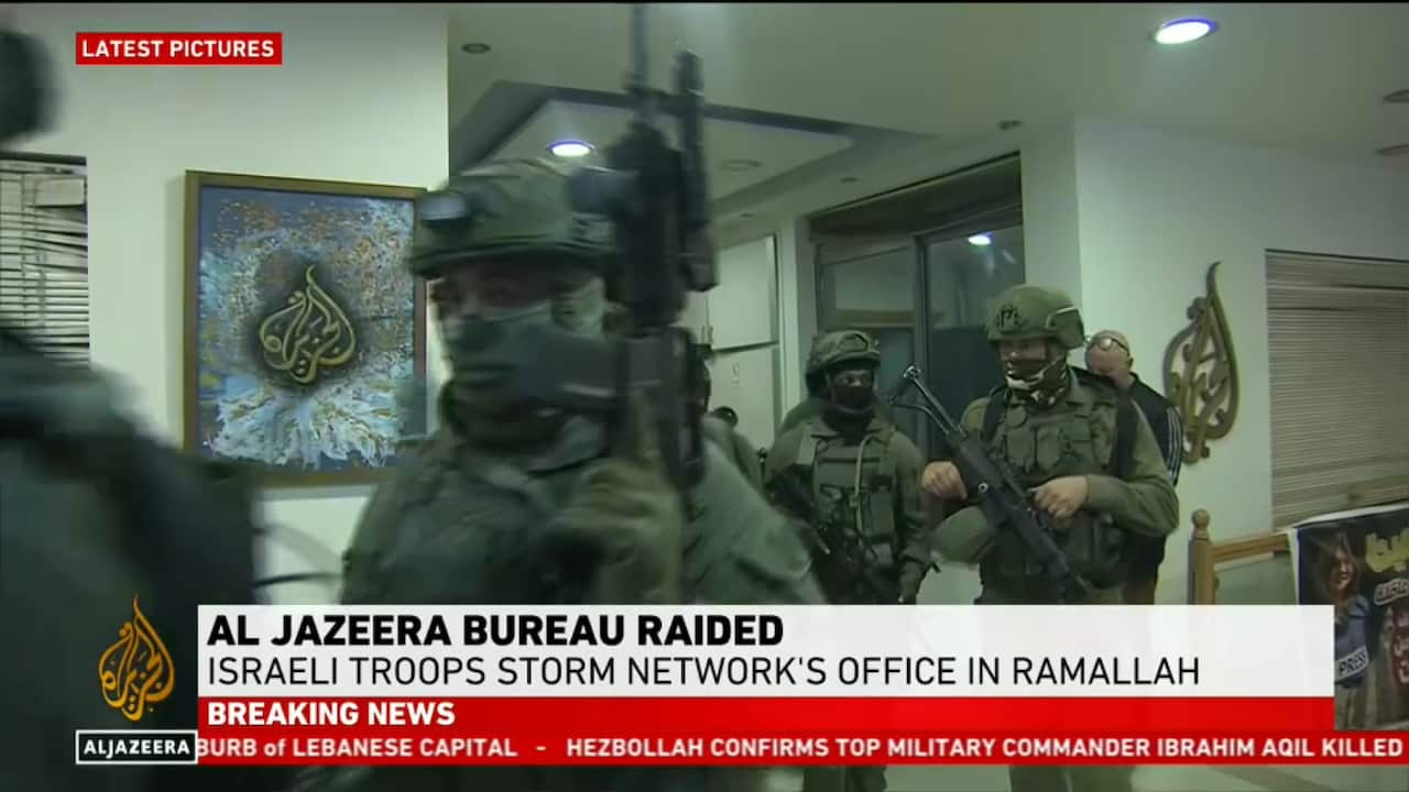 A screenshot of a broadcast news media report of soldiers inside an office