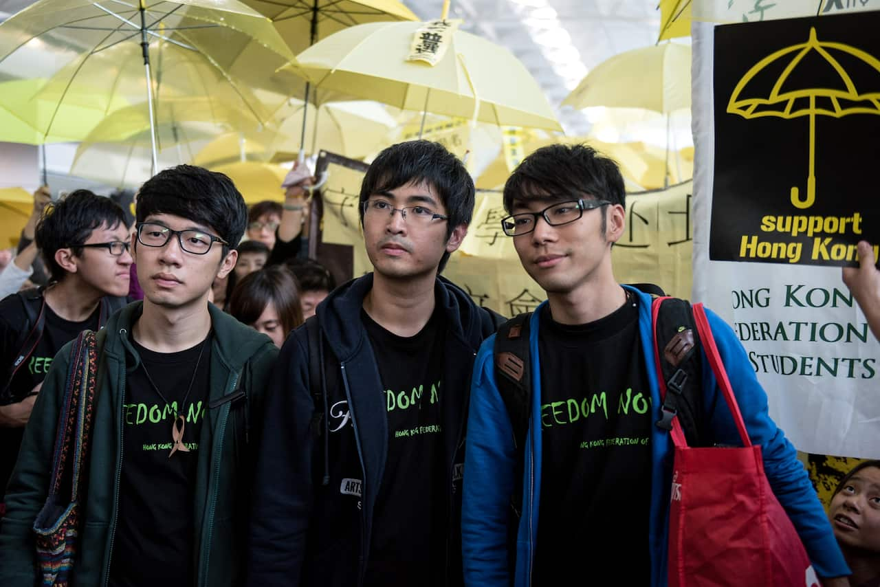 Three men surrounded by yellow umbrellas.