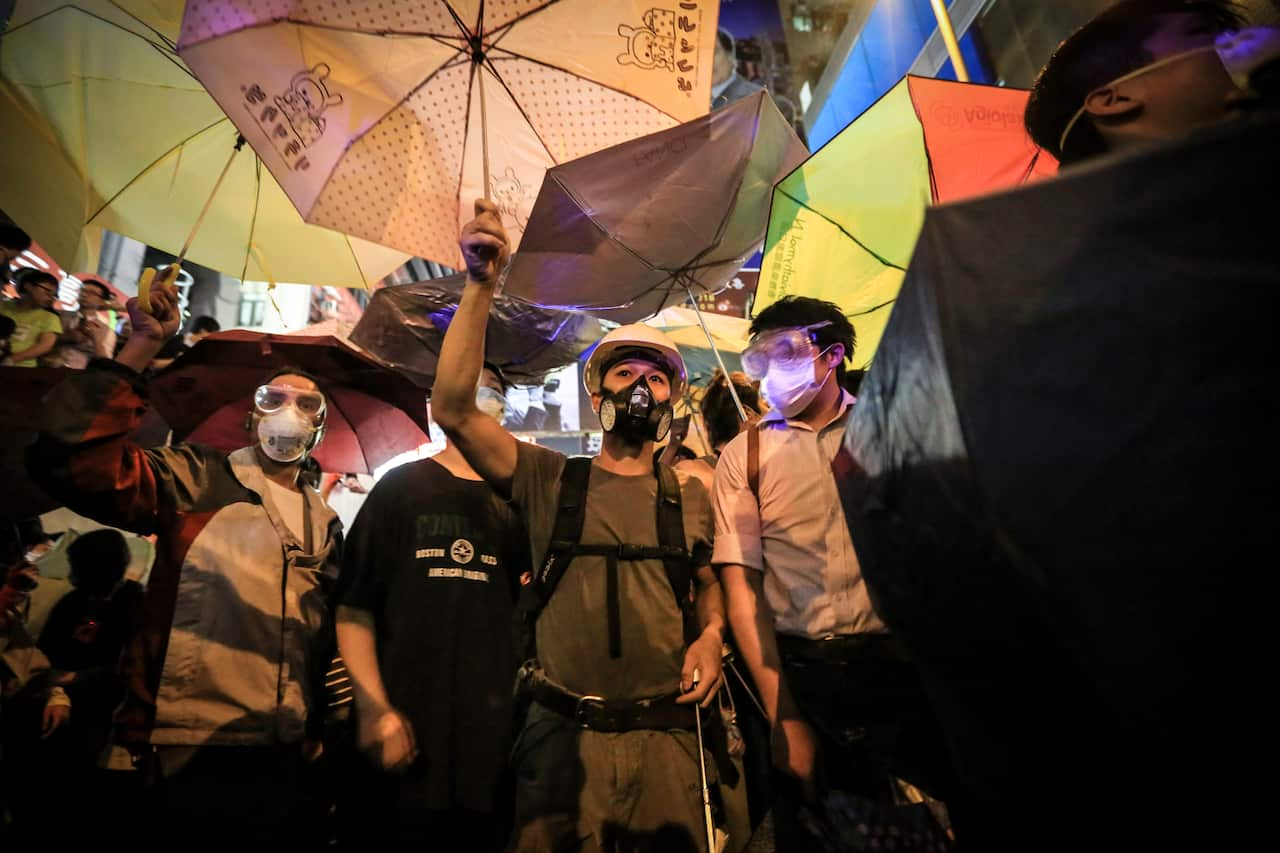 Protesters holding umbrellas.