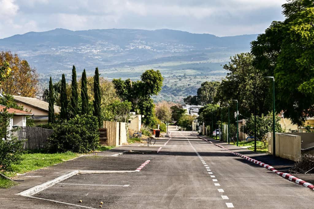 A view of an empty street with mountains in the background.