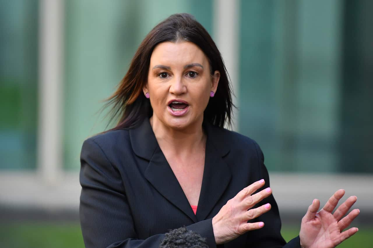 A woman in a navy blazer is speaking.